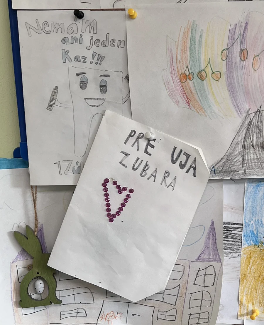 Kresby od malých pacientov na nástenke v ordinácii MUDr. Eduarda Hurtu — medzi nimi odkaz „Pre uja zubára“ a „Nemám ani jeden kaz!“